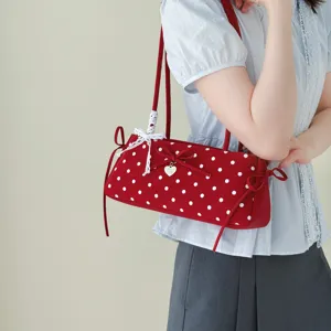 Detailed shot of the red polka dot underarm shoulder bag featuring a cute bow and lace trim.