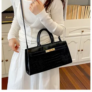 Detailansicht der schwarzen Krokomuster Handtasche mit dem klassischen Drehverschluss.