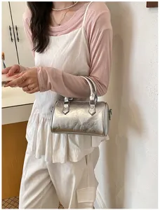 Trendy metallic silver barrel handbag for women, chic retro pillow crossbody bag style.