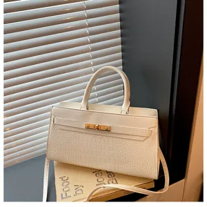 Weiße Handtasche mit Kroko-Muster, Henkel und elegantem Metallverschluss für Damen.