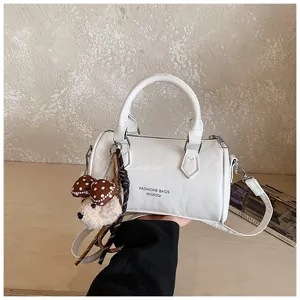 White cylindrical pillow handbag with cute bear pendant, retro crossbody bag for women.
