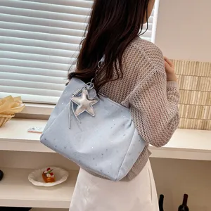 Light blue star pattern tote bag detail showcasing silver star charm and chain strap style.