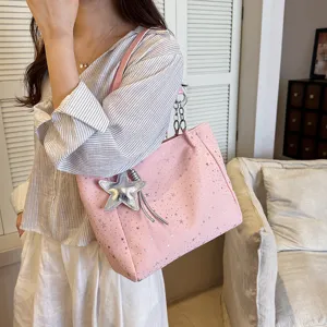 Pink star tote bag with chain strap and star charm, casual shoulder bag detail view.