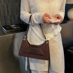 Stylish dark brown trapezoid shoulder bag with chic crocodile embossed flap and strap.
