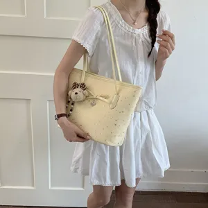 Chic yellow tote bag for women, featuring cute star print and bow detail with sweet bear charm.