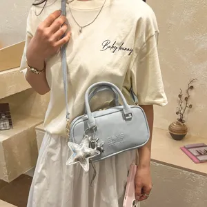 Light blue women's crossbody bag detail, featuring minimalist solid color design and metal hardware.