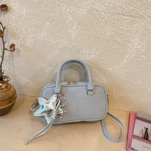 Light blue Boston handbag detail with stylish silver star pendant and comfortable dual top handles.