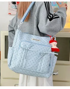 Bonito bolso tote de lunares azul claro con lazos y colgante de manzana para uso diario.