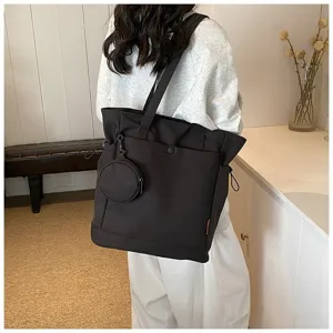Large capacity daily tote bag detail with attached coin pouch, shoulder straps and side drawstrings.