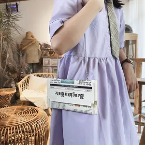 Vue détaillée du sac bandoulière tendance en cuir PU avec imprimé journal créatif et chaîne.