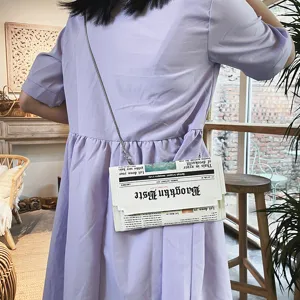 Sac bandoulière enveloppe en cuir PU imprimé journal avec bandoulière chaîne pour femmes