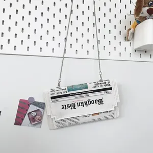 Sac bandouliere en cuir PU style enveloppe avec impression journal et texte gothique.