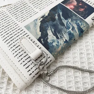 Sac bandoulière en cuir PU imprimé journal vintage avec chaîne en métal et fermoir.