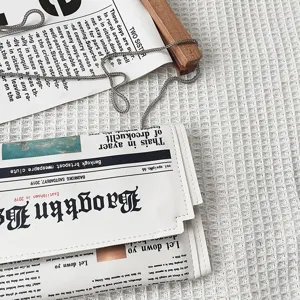 Gros plan détail du sac bandoulière enveloppe en PU avec motif de journal créatif