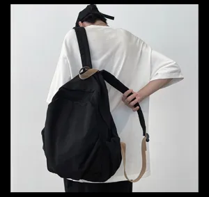 Detailansicht des schwarzen Canvas-Rucksacks mit khakifarbenen Kontrastgurten am Model.