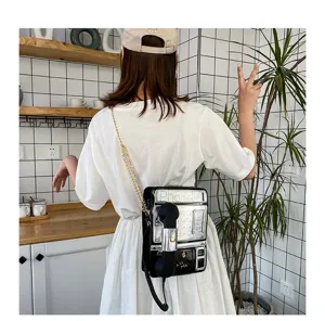 Kreative Umhängetasche in Telefonform mit Retro-Design, metallischer Kette und Hörer.