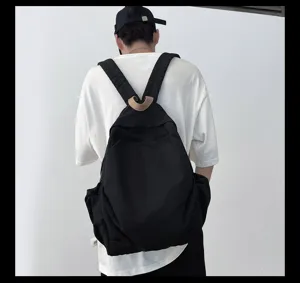 Detailansicht eines minimalistischen schwarzen Rucksacks am Model, lässiger Alltagsstil.