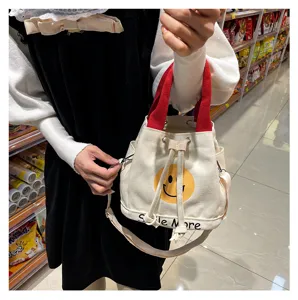 Canvas Beutel Tasche mit gelbem Smiley Gesicht, roten Griffen und verstellbarem Schultergurt.