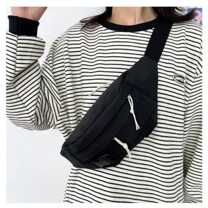 Schwarze Canvas-Brusttasche für Damen, minimalistische Streetwear-Umhängetasche mit Reißverschluss.