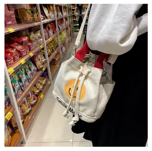 Leinwand Eimer Tasche für Frauen süßes Smiley Gesicht lässige Handtasche mit roten Griffen.