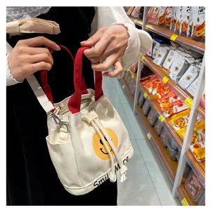 Leinen Eimer Handtasche mit süßem Smiley-Druck, roten Trägern und praktischem Kordelzug.