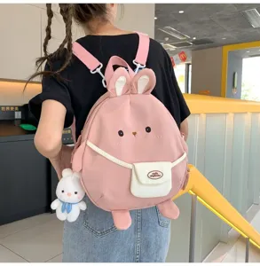Vista dettagliata zaino coniglio carino, design nylon rosa con pendente e orecchie dolci.