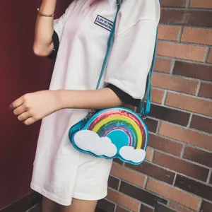 Primer plano del bolso cruzado de lentejuelas con arco iris y nube, detalles brillantes.