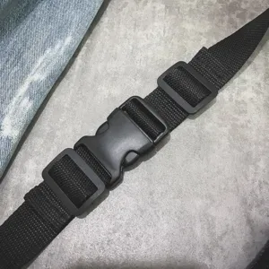 Schwarzes Nylon Taschengurt Detail mit stabiler Kunststoff Steckschnalle und Schieber.