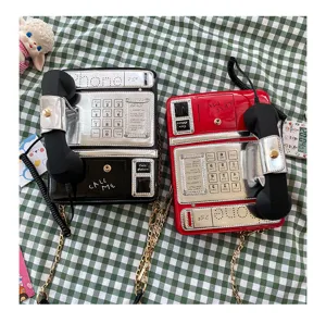 Detailansicht von ausgefallenen Telefon-Umhängetaschen in Schwarz und Rot mit Metallketten.