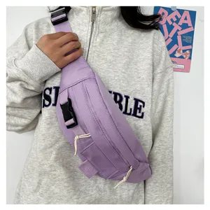 Detailansicht einer hellvioletten Retro-Brusttasche mit Schnalle und Kordelzug, lässig getragen.
