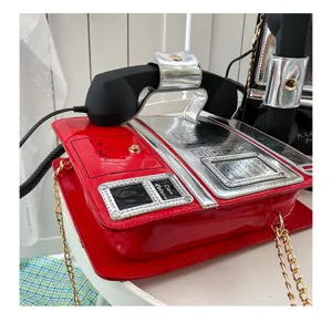 Kreative rote Lackleder Umhängetasche in Telefonform mit Kettengurt und Vintage Telefonhörer.