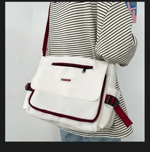 Canvas Umhaengetasche Detail mit rotem Besatz, Reissverschlusstasche und FASHION-Label Akzent.