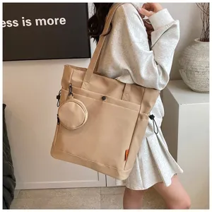 Large beige canvas tote bag detail view, casual shoulder bag with small coin pouch accessory.