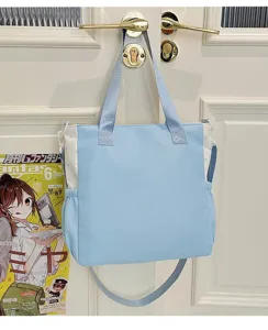 Detailansicht einer hellblauen Segeltuchtasche mit Seitentaschen und Sternmustern hängend.
