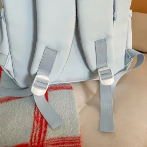 Nahaufnahme der hellblauen Rucksack-Schultergurte mit weißen verstellbaren Schnallen.