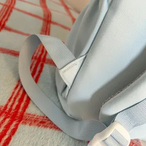 Nahaufnahme der hellblauen Rucksack-Schultergurt-Details mit robuster Naht und Schnalle.