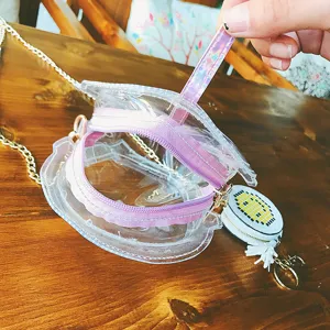 Transparente Jelly Umhängetasche mit lila Reißverschluss und süßem runden Kettenanhänger.