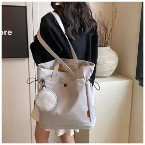 Detailed view of large capacity tote bag with coin purse worn on shoulder in room setting.