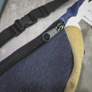 Nahaufnahme eines modischen Brustbeutels aus Denim und Canvas mit schwarzem Reißverschluss.