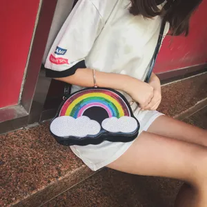 Vista detallada del bolso cruzado de nube y arco iris con lentejuelas coloridas y gran textura.