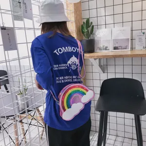 Vista detallada de un bolso cruzado de lentejuelas con arcoíris llevado en un café moderno.