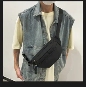 Schwarze Umhängetasche von Model getragen, zeigt urbanen Streetwear-Stil mit verstellbarem Gurt.