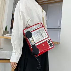 Detailansicht der kreativen Retro-Telefon-Umhängetasche mit rotem und silbernem Glanzfinish.