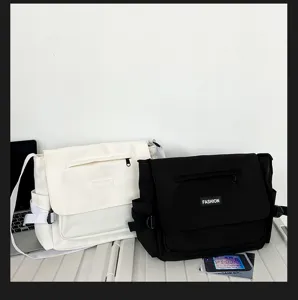 Lockerer Segeltuch-Umhängetasche Detail mit zwei Farboptionen und praktischer Vordertasche.