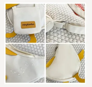 Detailansicht der niedlichen Enten-Leinwand-Brusttasche mit wasserdichtem Stoff und Beschlägen.