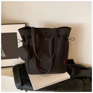 Detailed shot of a black canvas tote bag with small round coin purse, large capacity.