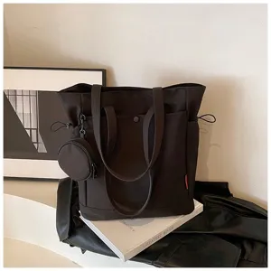 Detail view of large capacity dark brown tote bag featuring coin purse and double shoulder handles.