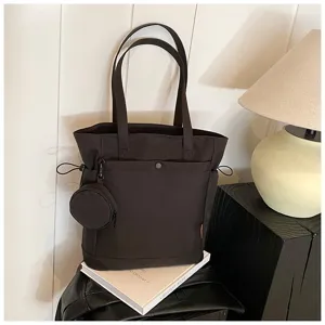 Dark brown canvas tote bag detail featuring dual straps, side drawstrings and attached coin pouch.