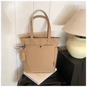 Khaki canvas tote bag detail, featuring dual shoulder straps, front pocket, and coin pouch.