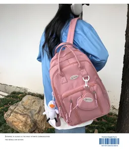 Vista detallada de mochila informal rosa con gran capacidad y bonito colgante.